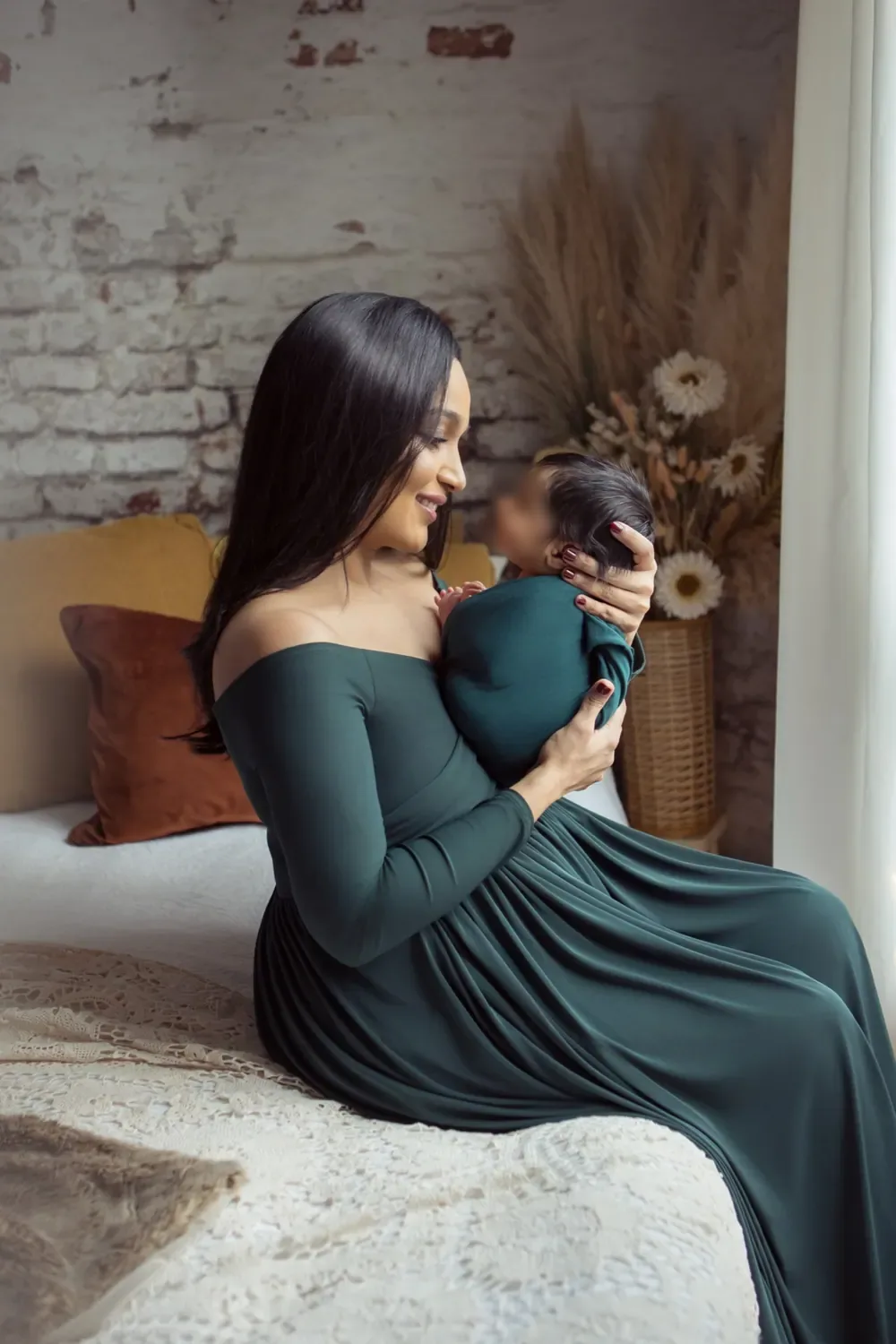 Dr. Nidhi in an emerald dress cradling her newborn
