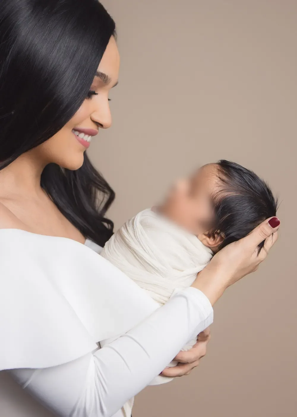 Dr. Nidhi holding her swaddled newborn