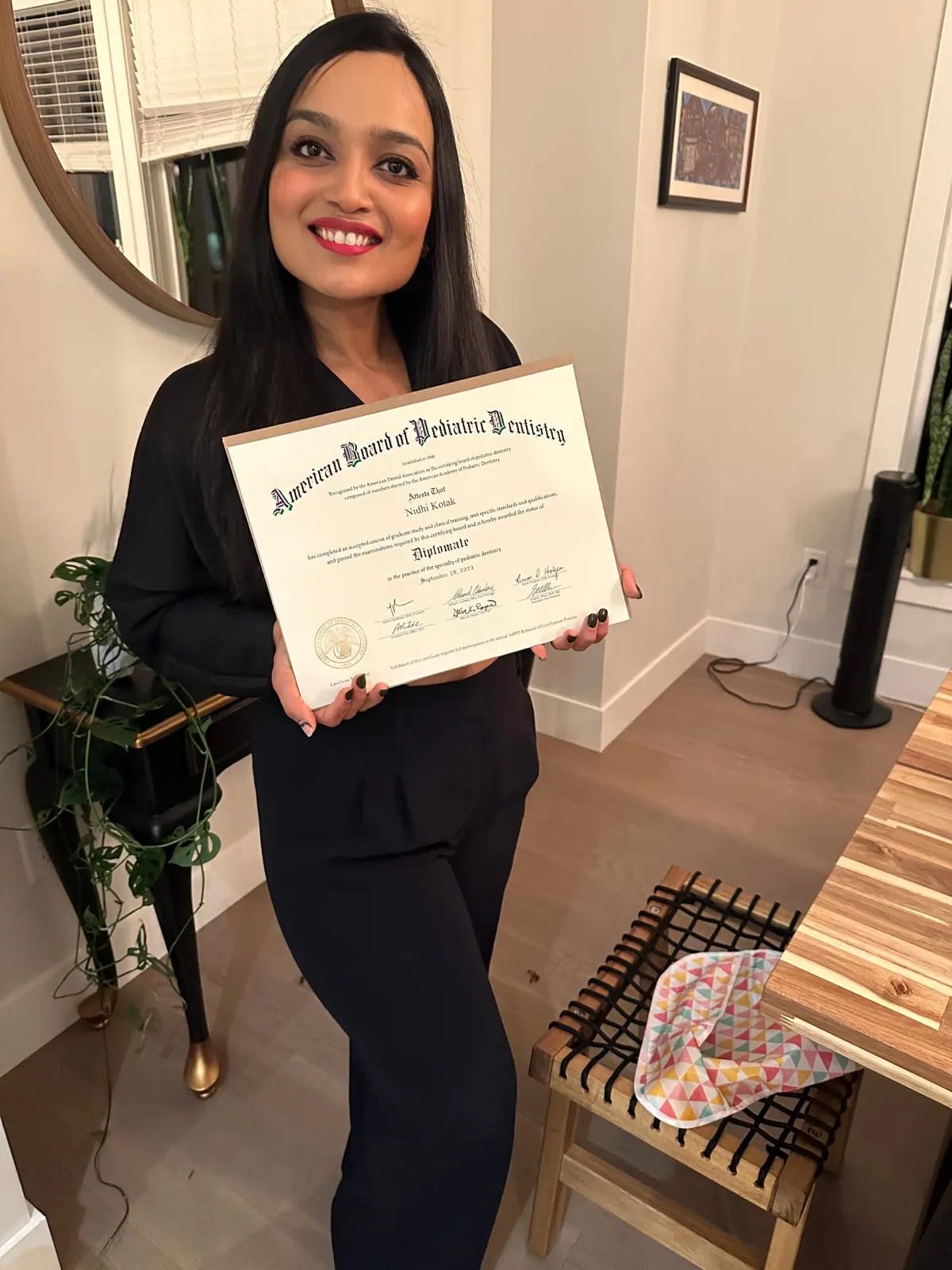 Dr. Nidhi holding her American Board of Pediatric Dentistry Diplomate certificate