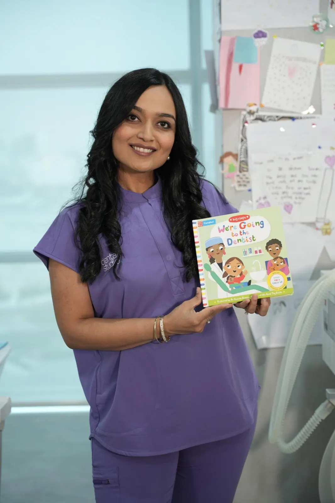 Dr. Nidhi with a children's book about visiting the dentist