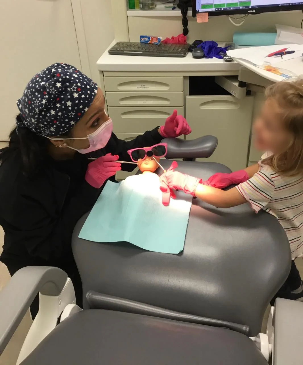 Dr. Nidhi showing a toddler how the visit works on a doll first